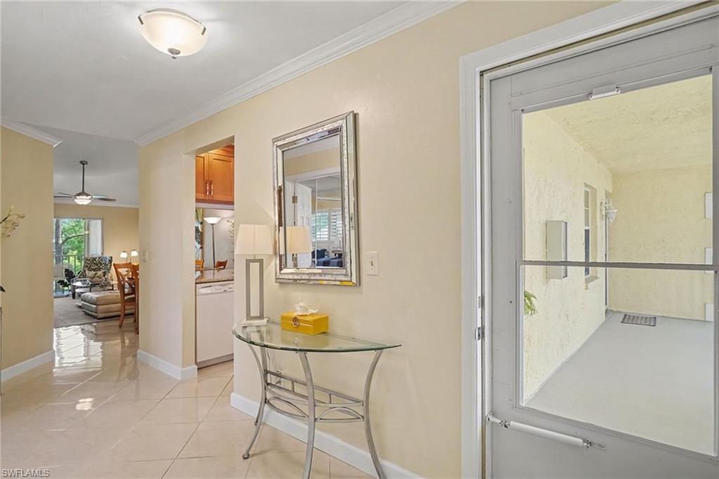 Condo entryway with tiled floors, a glass console table, and a door to the screened lanai.