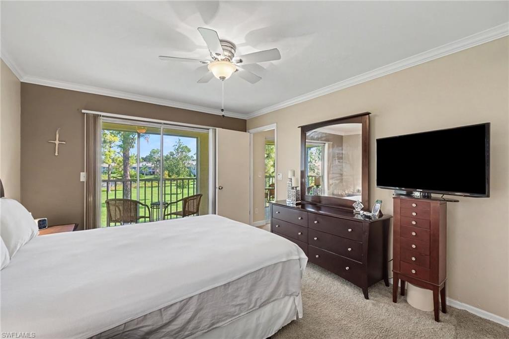 Bedroom with a white bed, dark wood dresser, and sliding glass door to a balcony.