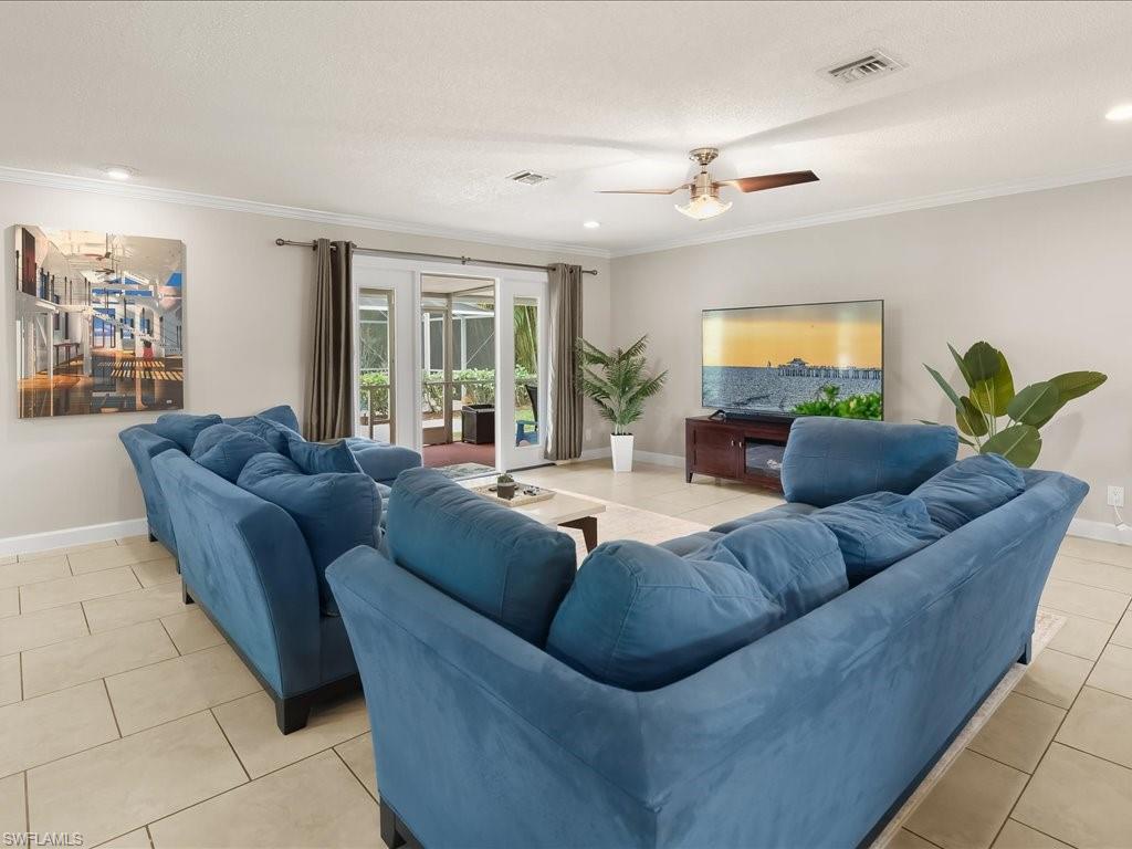 Living room with a blue sectional sofa, tiled floors, and sliding glass doors to a patio.