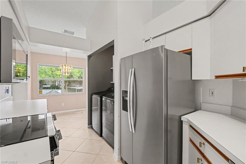 Kitchen with stainless steel appliances and a washer and dryer in a recessed laundry nook.