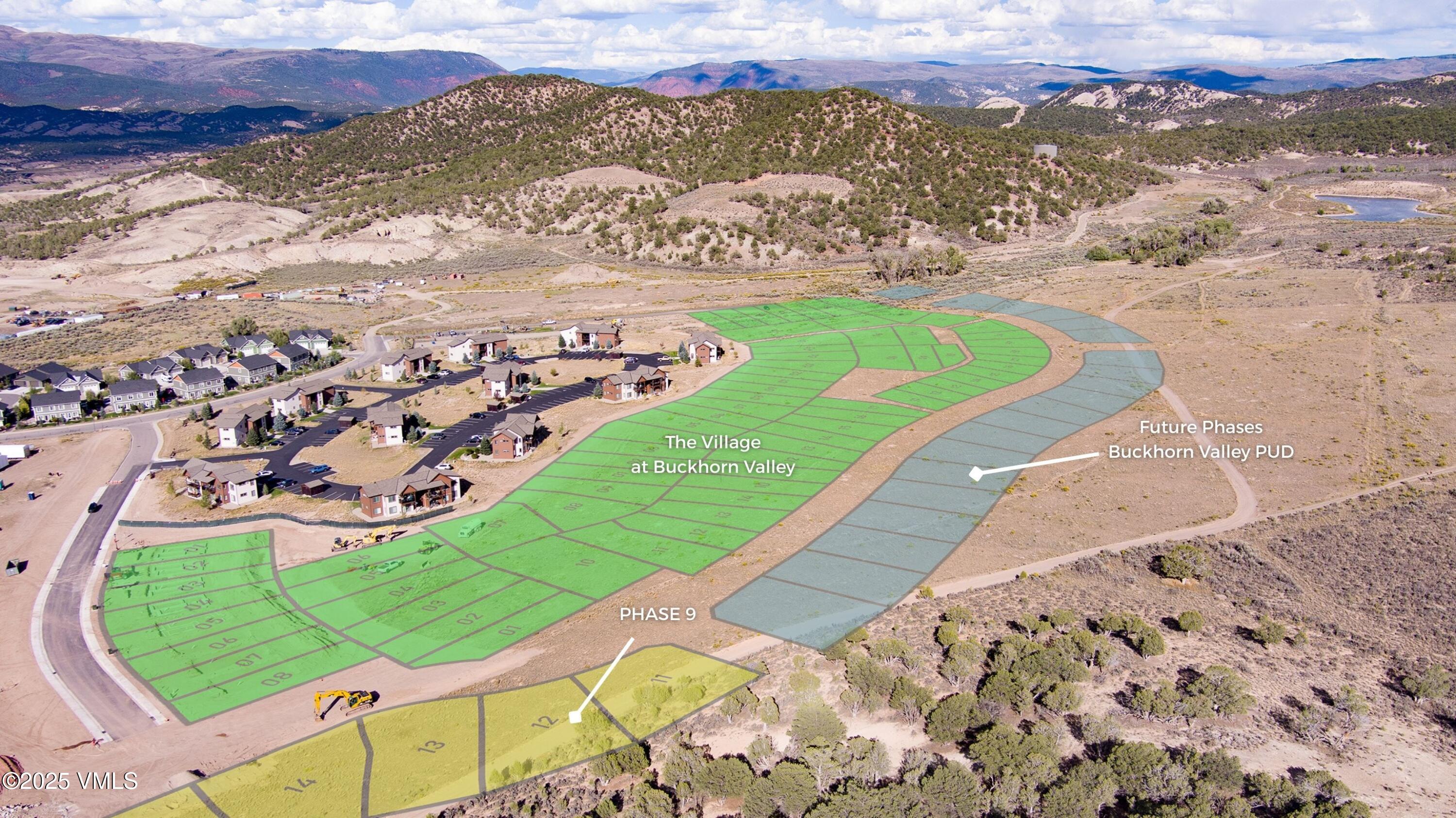 Aerial development plan showing colored lots, Phase 9, future phases, and nearby homes against a mountain backdrop.