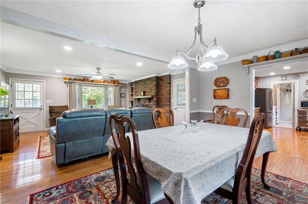 Open-plan dining and living area with a brick fireplace and blue leather sofa.