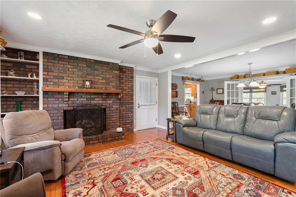 Living room with brick fireplace, built-in shelves, gray sectional, and patterned rug.