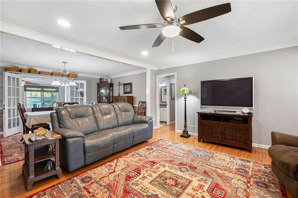 Living room with gray leather sofa, patterned rug, hardwood floors, and television.