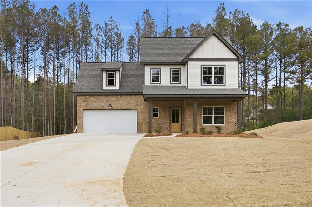 Two-story brick and white-sided home with an attached garage and broad driveway.