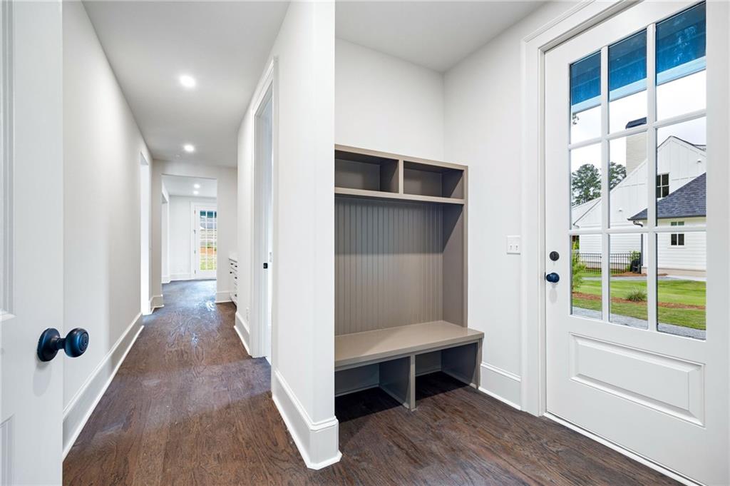 Entryway with built-in bench and cubbies beside a glass-paneled front door.