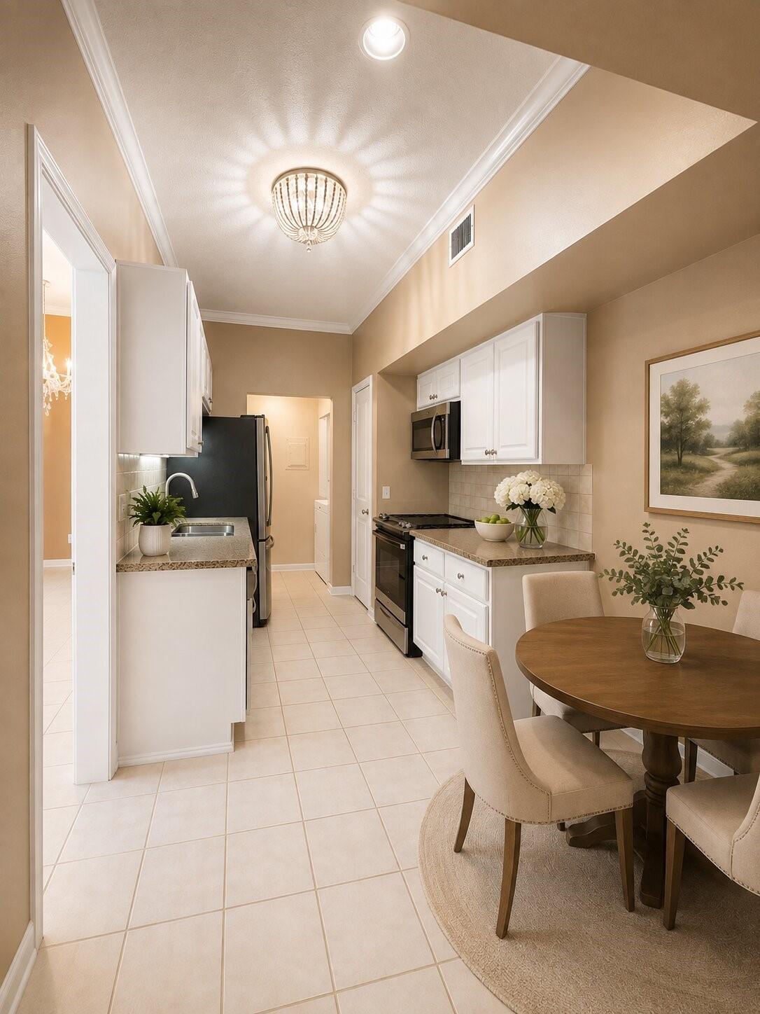 Kitchen and dining area with white cabinets, stainless steel appliances, and a round wooden table.