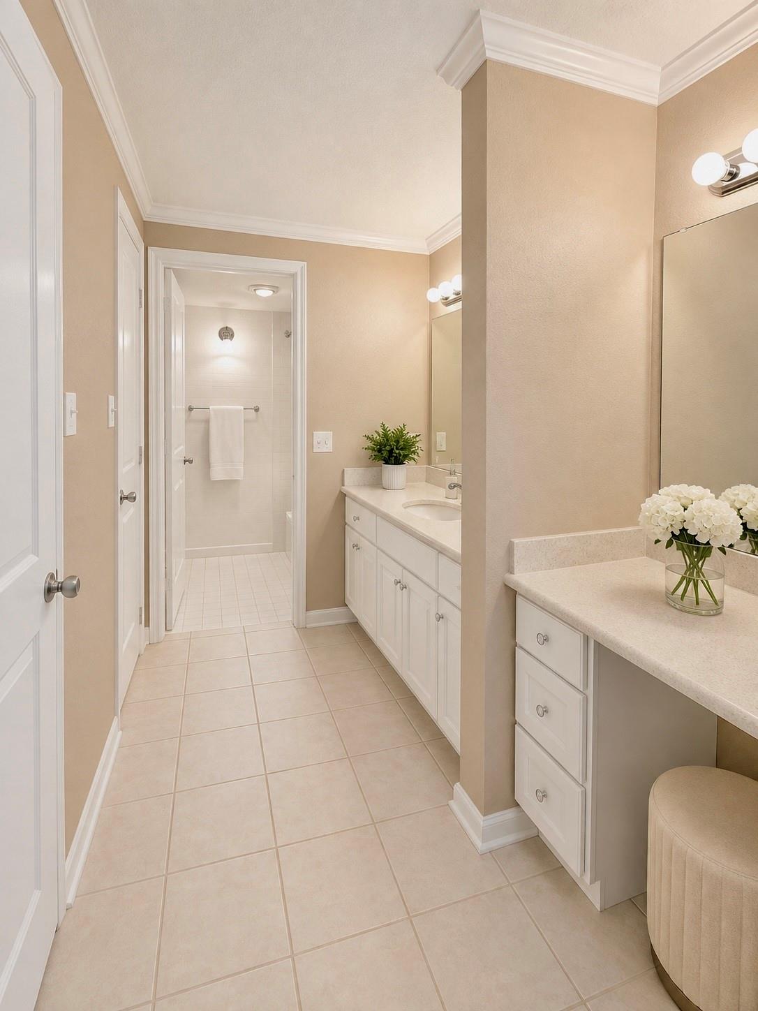 Bathroom with two white vanities and a doorway to a tiled shower.