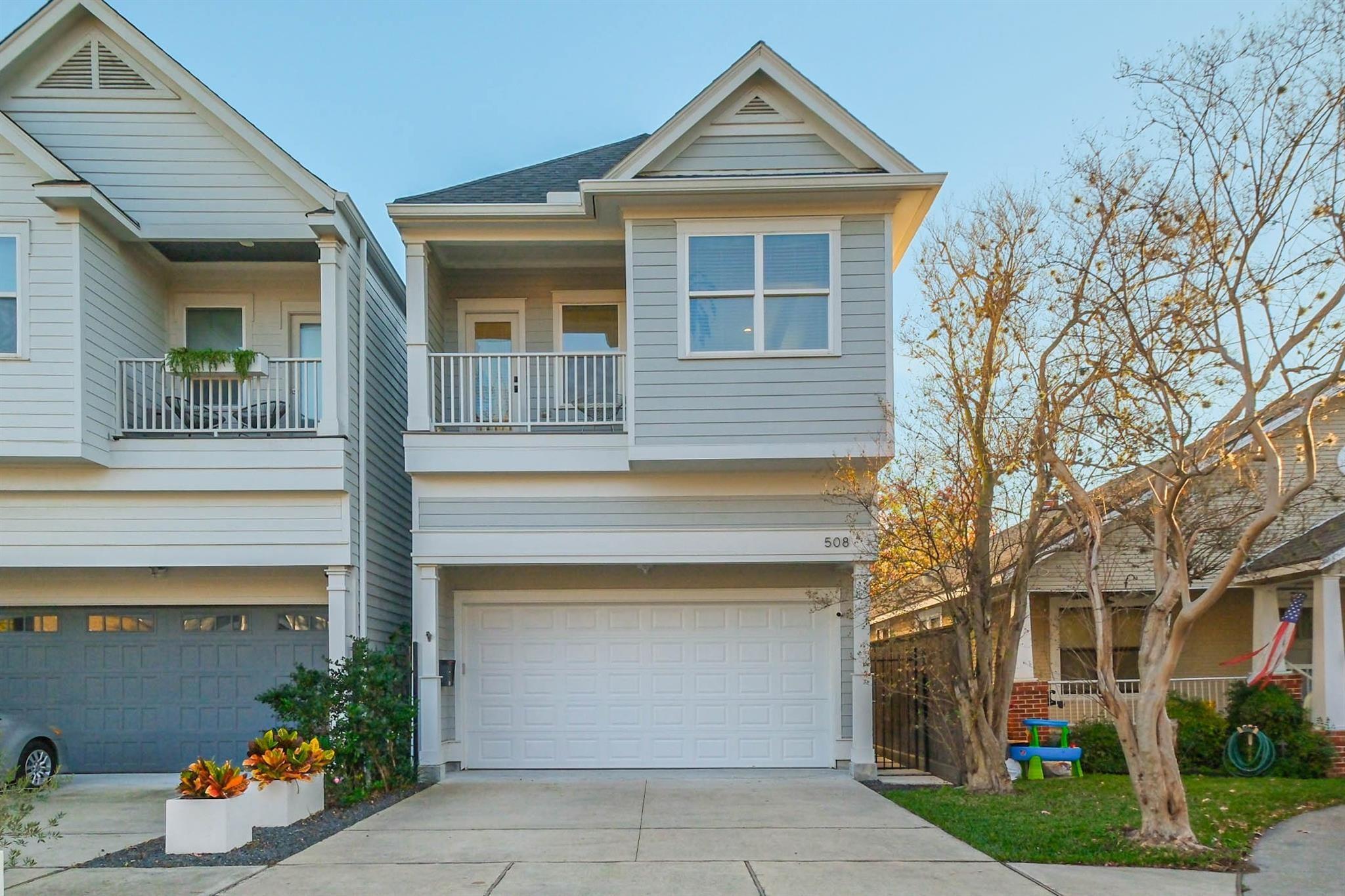 Gray two-story house with a front balcony and white garage door, number 508 above the garage.