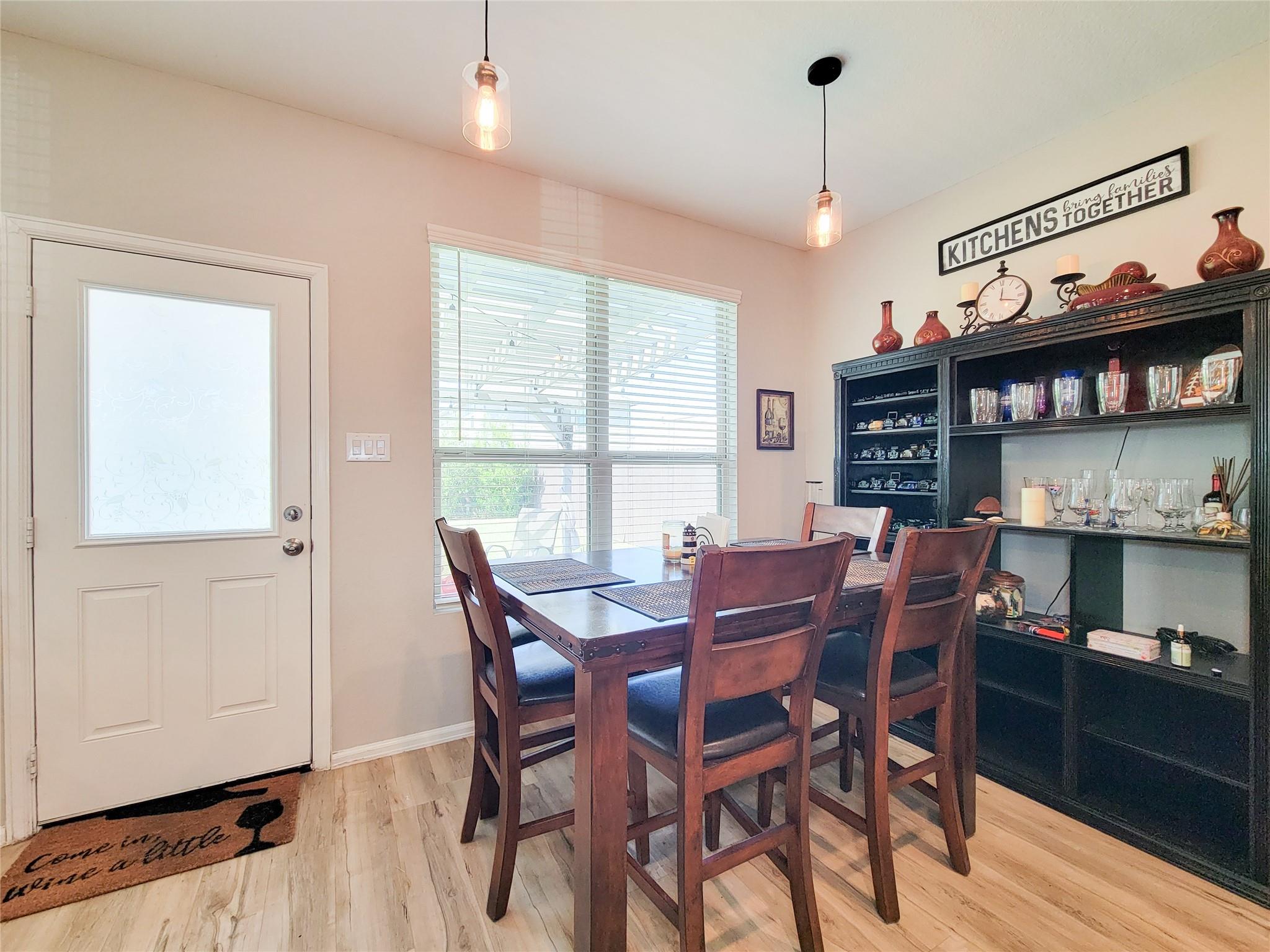 Dining room with a dark wood table, chairs, and a large black glassware cabinet.