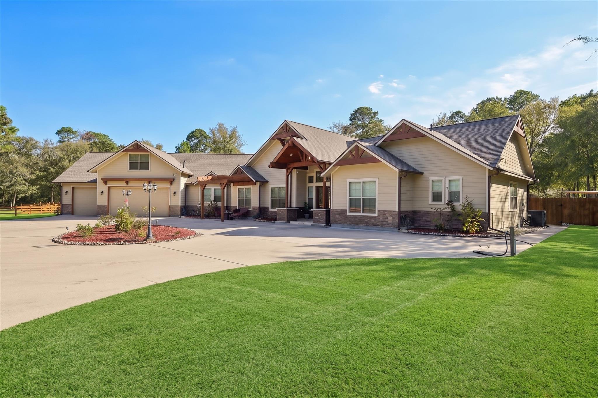Large beige home with timber-trimmed gabled entry, attached garage, broad driveway, and expansive green lawn.