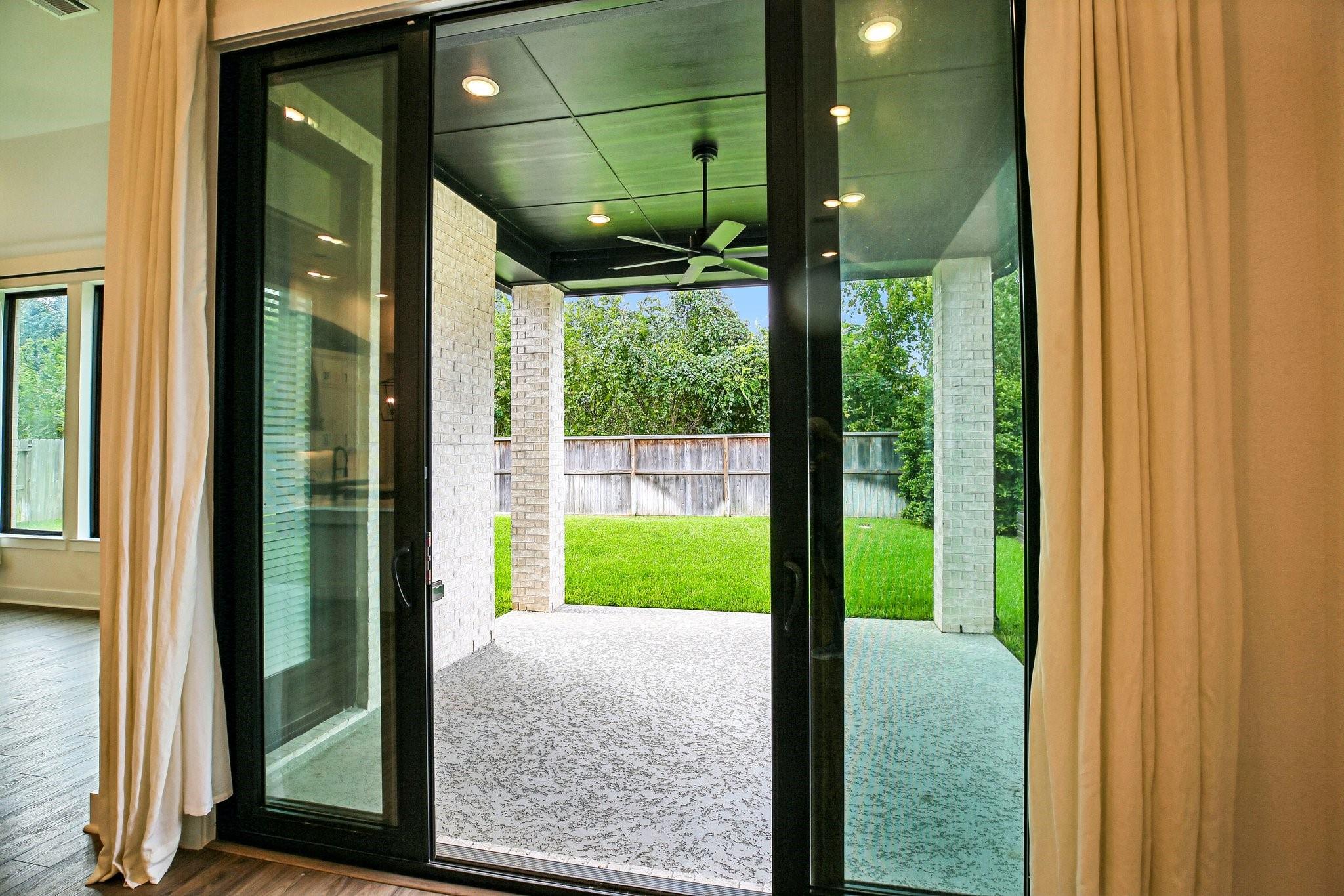 Sliding glass doors open to a covered patio and fenced backyard.