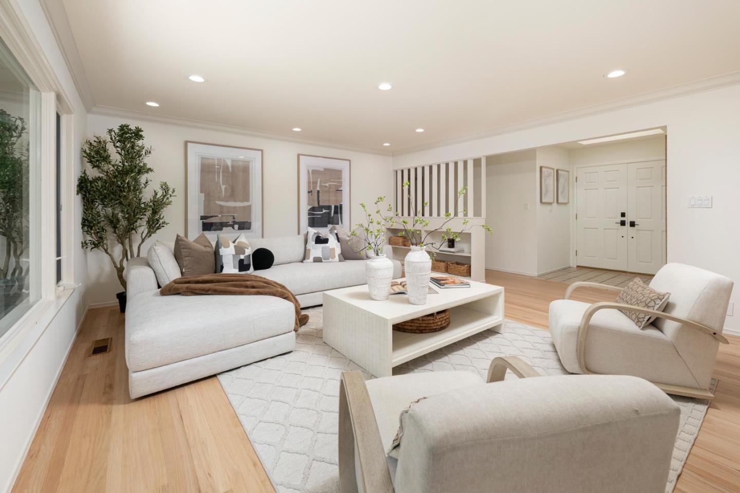 Staged living room with a white sectional, armchairs, and a coffee table.