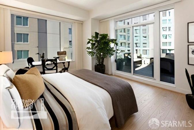 Bedroom with a large bed, broad windows, and views of neighboring city buildings.