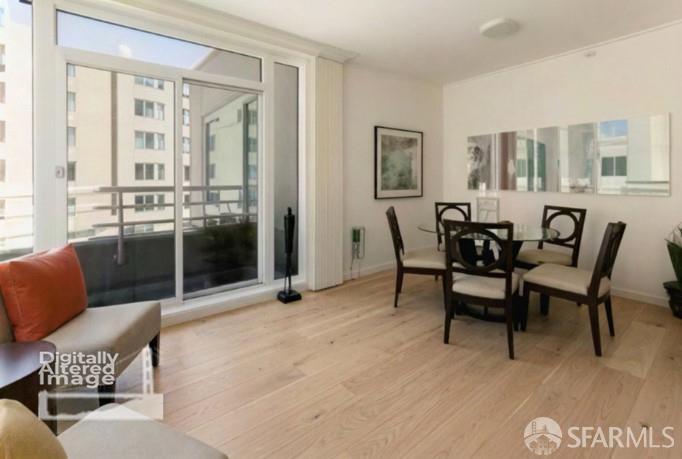 Dining area with a dark table and chairs beside sliding glass doors opening to a balcony.