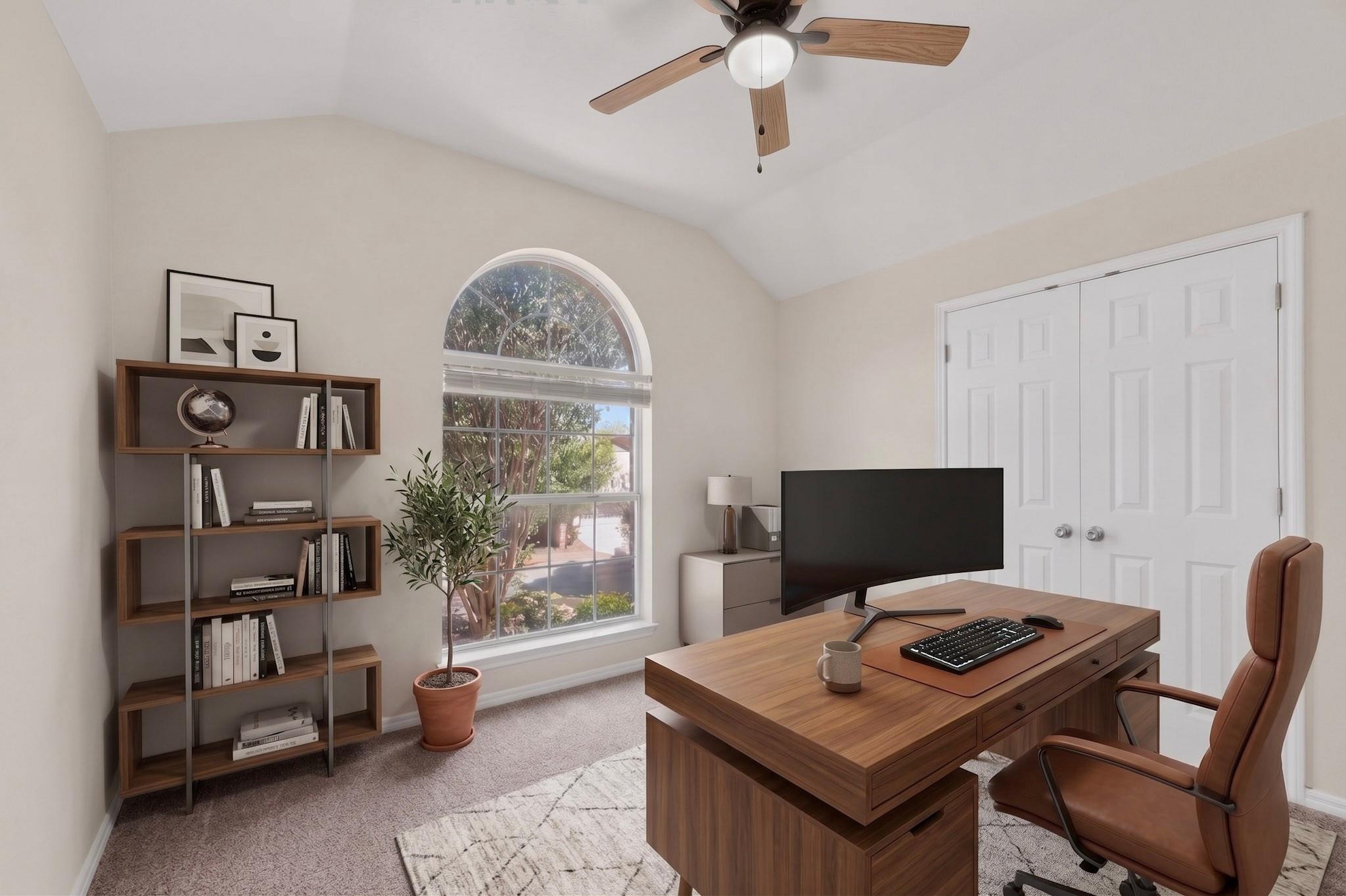 Furnished home office with a wood desk, leather chair, and arched window.