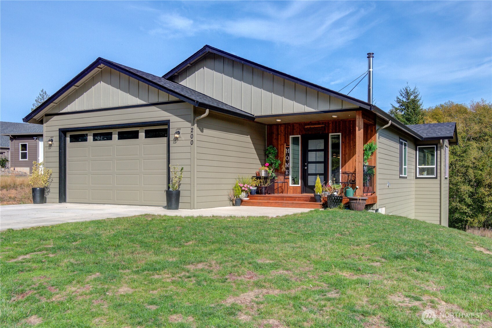 Single-story home with a two-car garage and wood-paneled front porch.