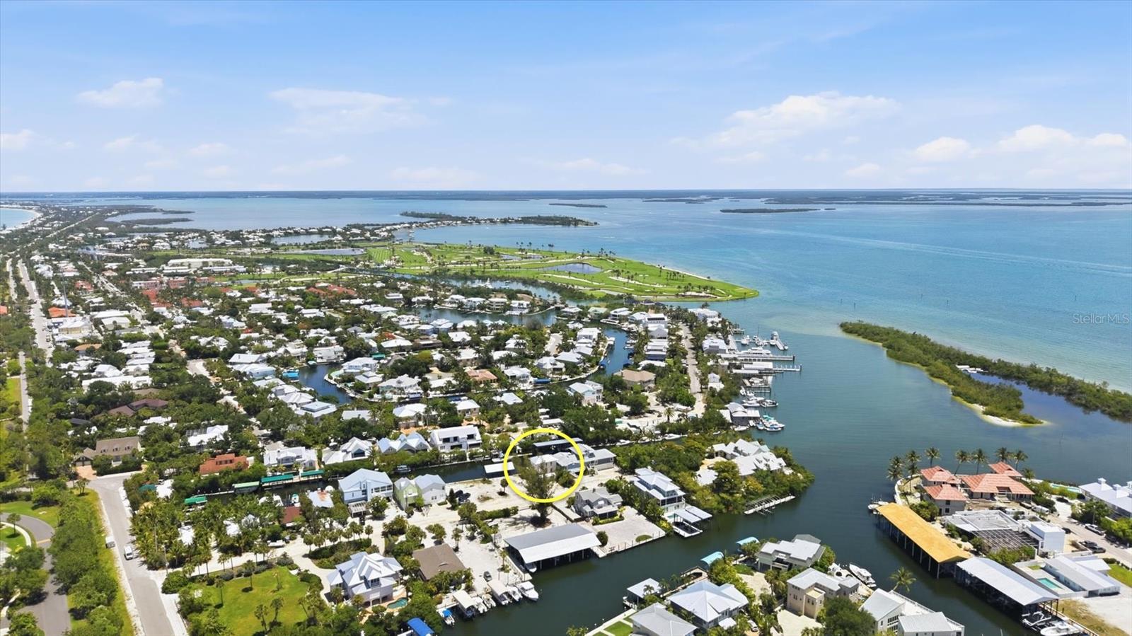 Aerial view of 171 Damfiwill St, circled among waterfront homes and canals beside Boca Grande’s blue bay.