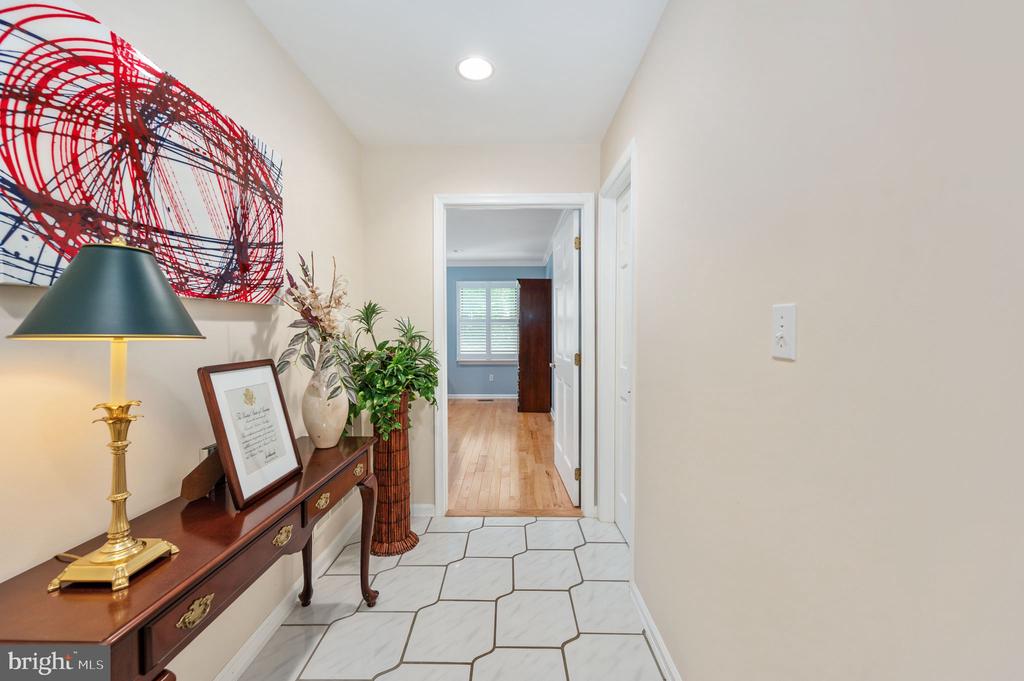 Entry hall with geometric tile flooring, a dark wood console table, and red abstract wall art.