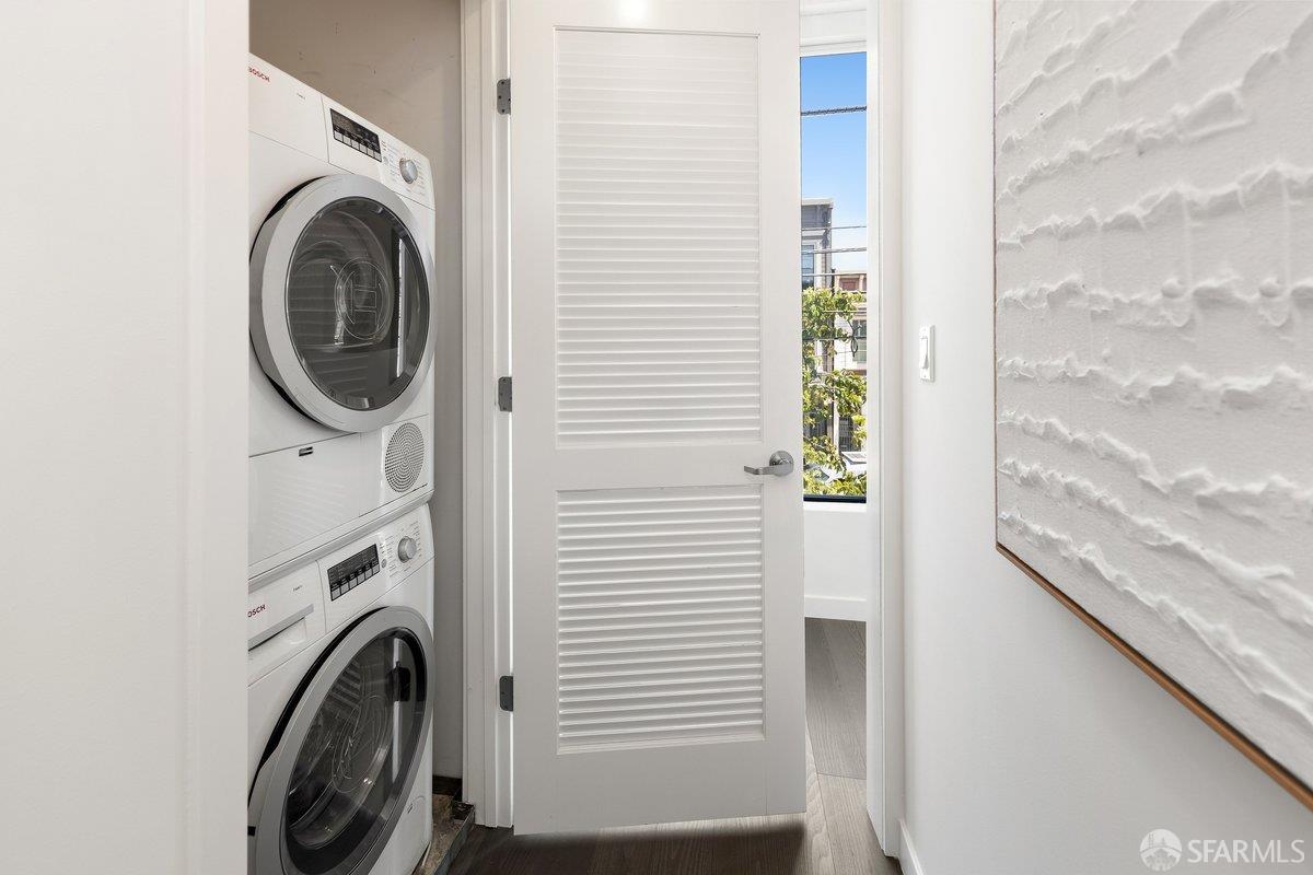 Stacked Bosch washer and dryer in a laundry closet behind an open louvered door.