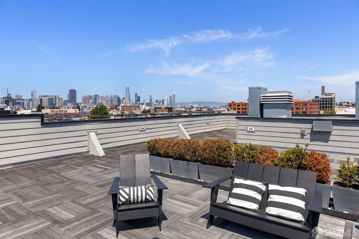 Rooftop terrace with lounge seating and planters overlooking the San Francisco skyline.