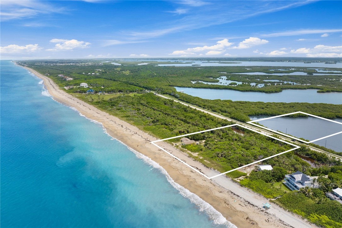 Aerial view of a beachfront property outlined beside the ocean and coastal wetlands.