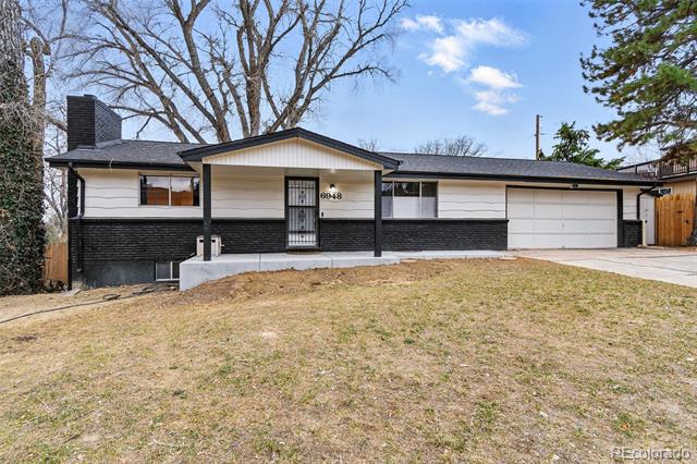 Ranch-style house with black-and-white siding, a covered entry, and an attached garage.