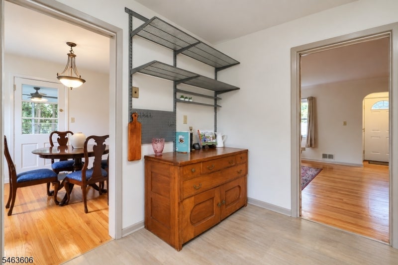 Interior passage with a wooden buffet and open shelving between the dining room and front entry.