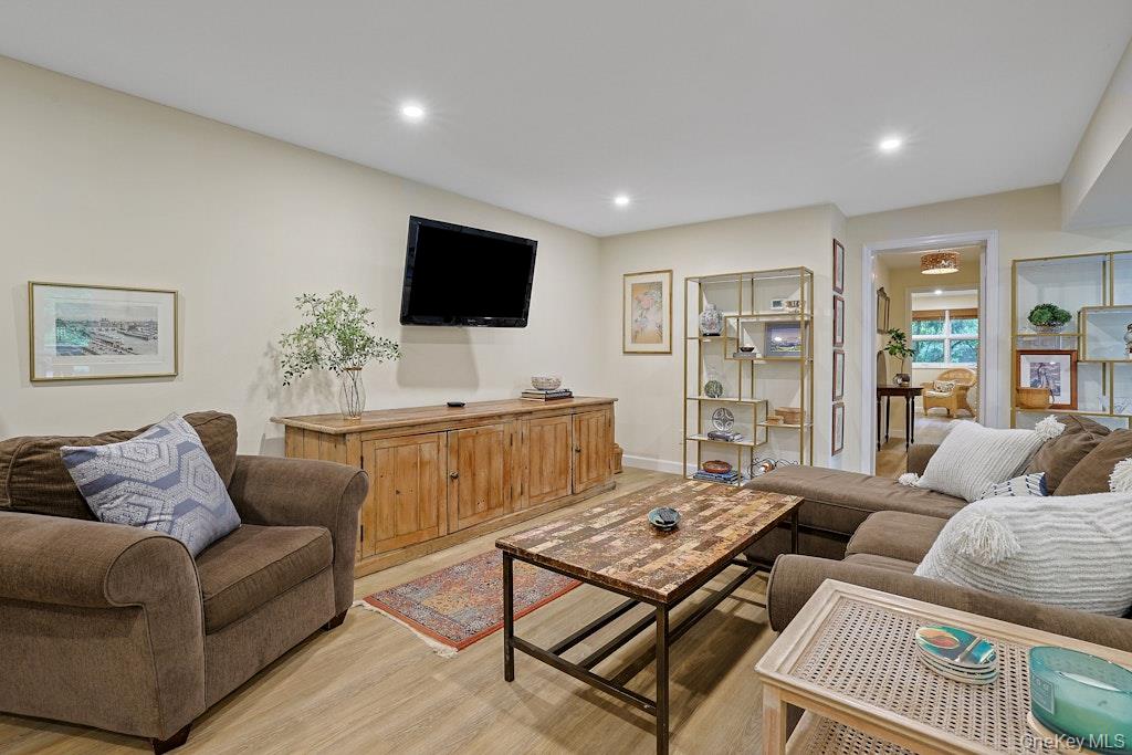 Living room with brown sofas, a rustic wooden media console, and a distressed wood coffee table.