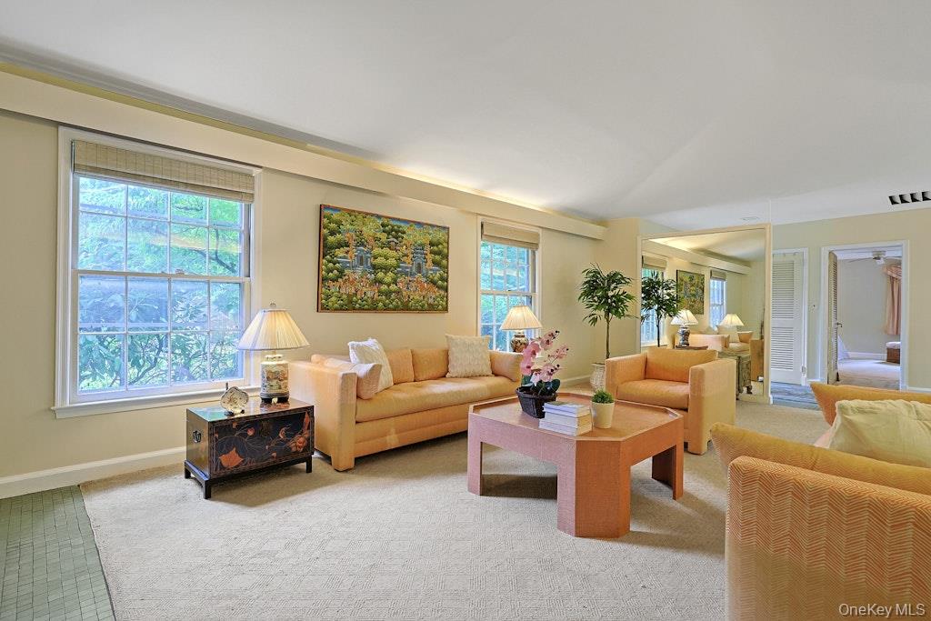 Living room with peach seating, large windows, and a wooden coffee table