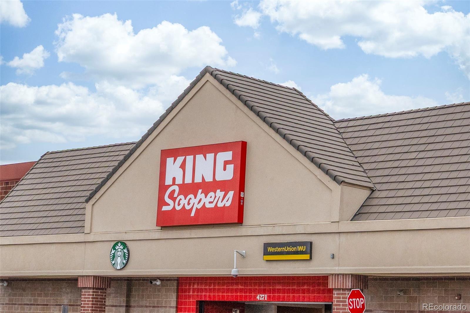 King Soopers storefront with Starbucks and Western Union signs beneath a tiled roof.