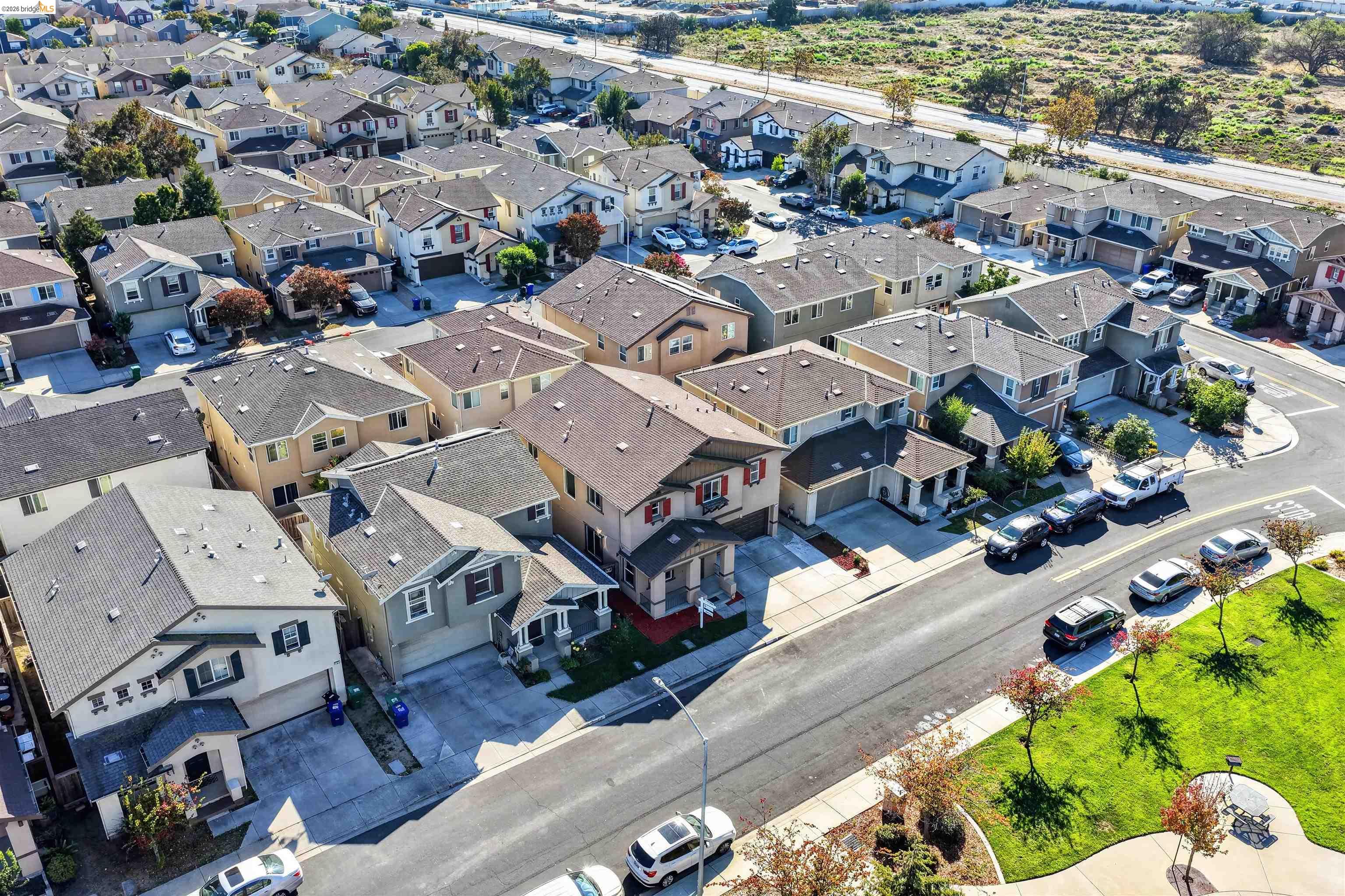 Aerial view of a dense neighborhood of homes beside a small park.