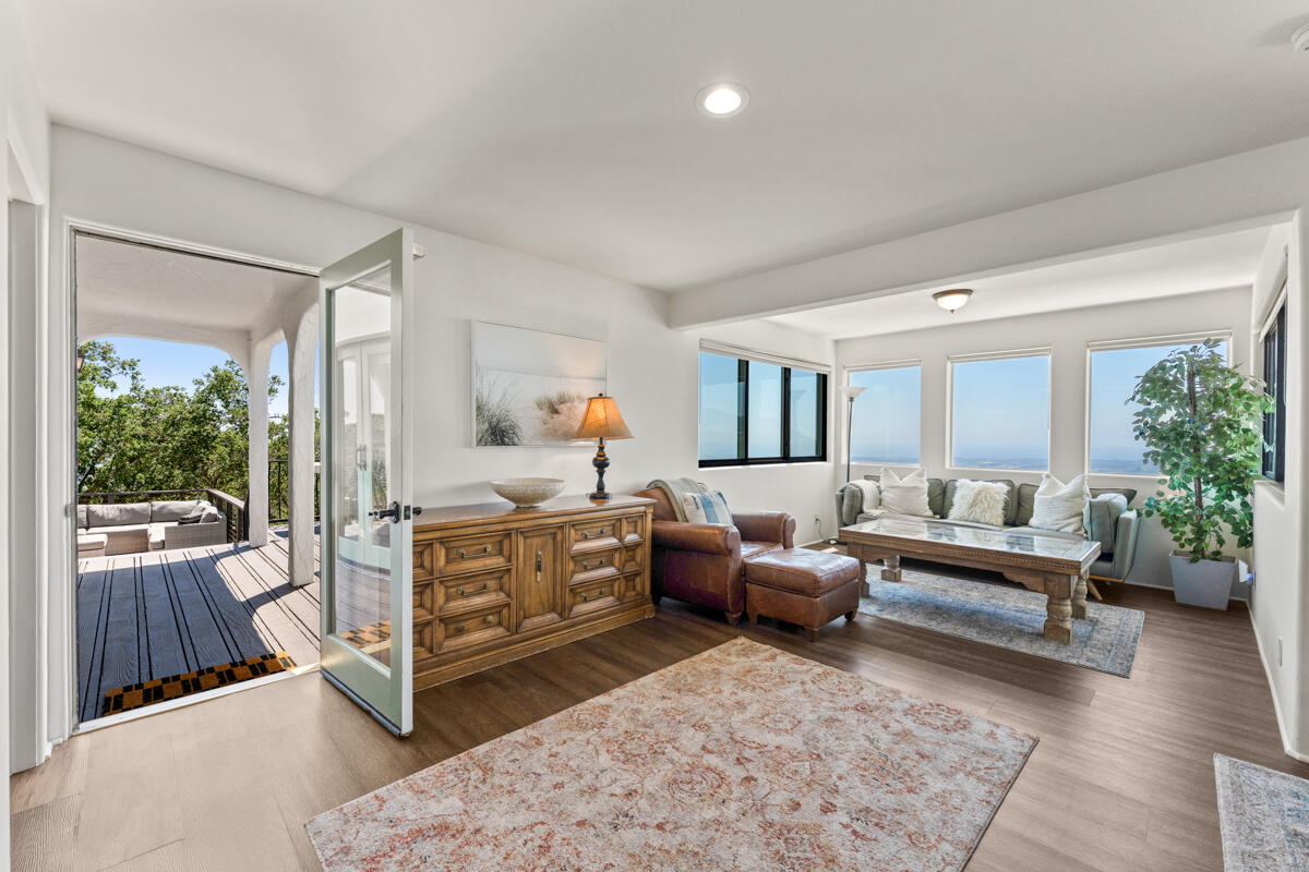 Furnished living room with ocean views and an open glass door leading to a covered deck.