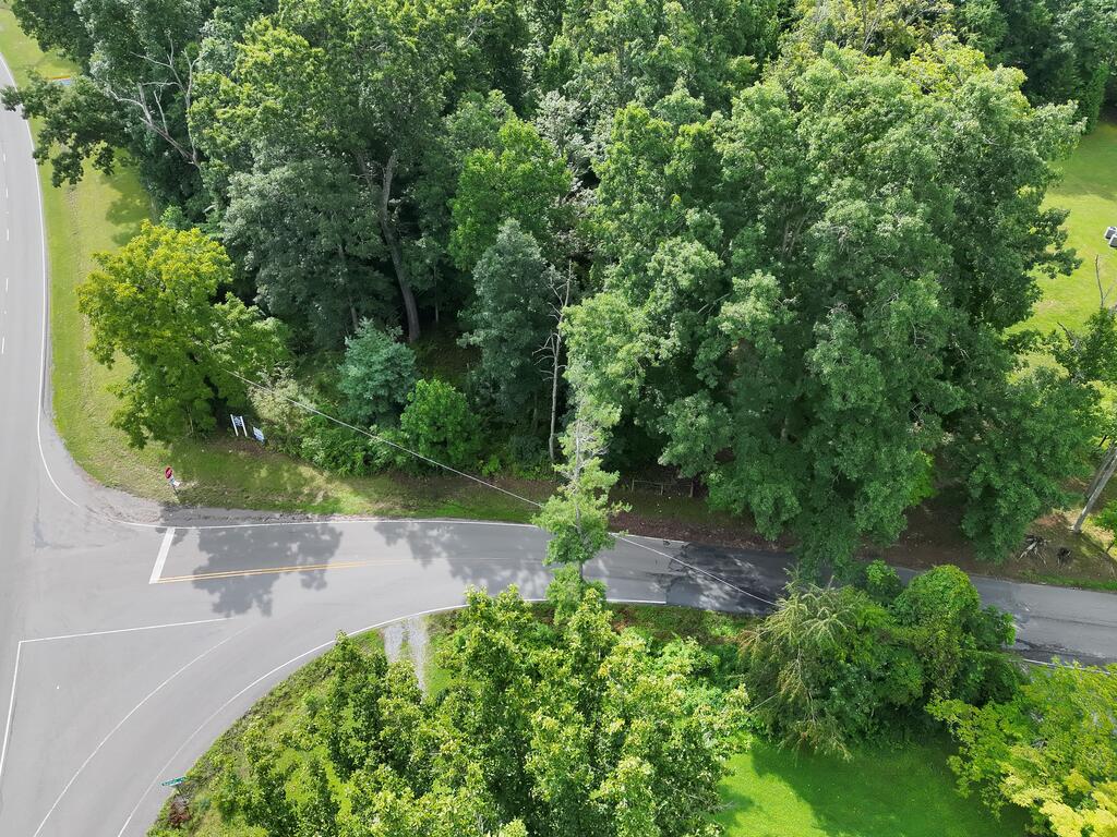 Aerial view of a wooded parcel bordered by roads at a highway intersection.