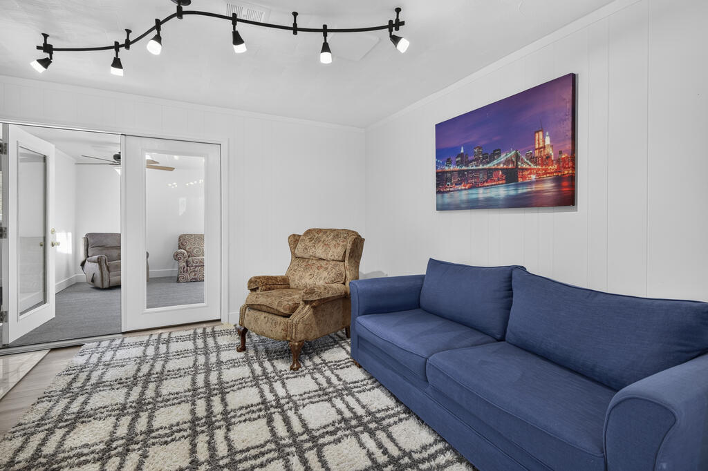 Living room with a blue sofa, patterned armchair, and framed cityscape artwork.