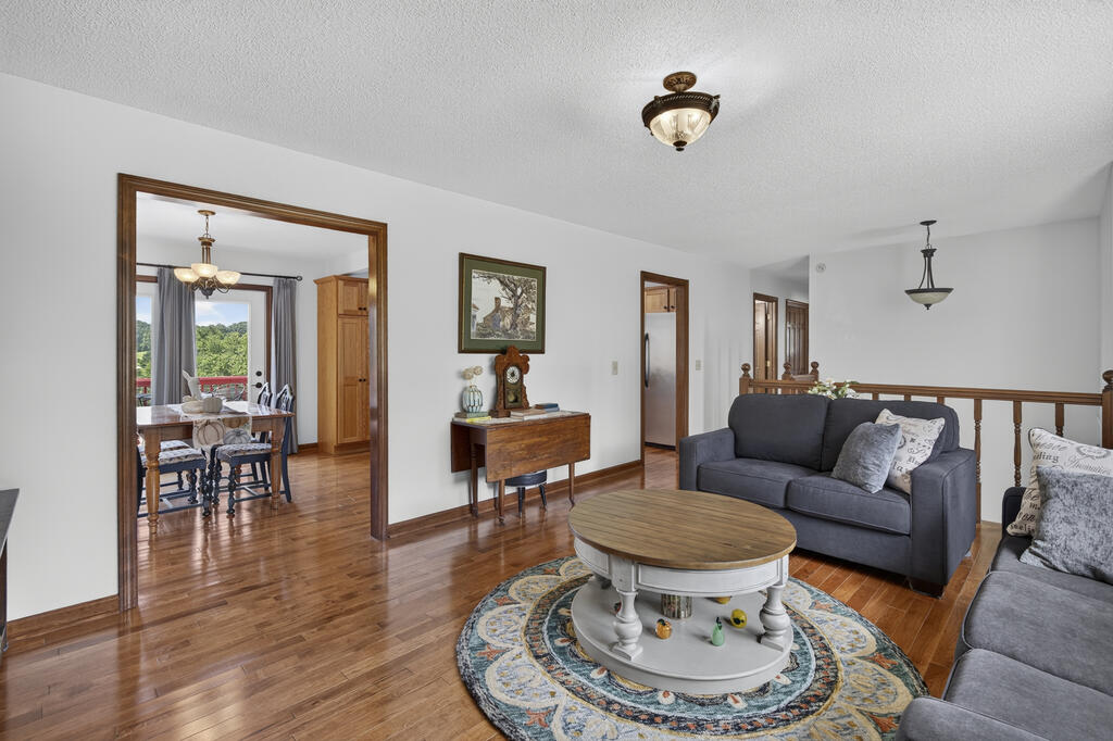 Living room with gray sofas and a round coffee table; dining area visible through the doorway.