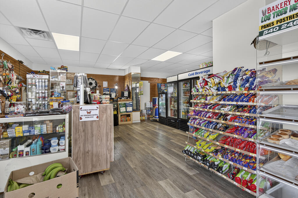 Convenience store interior with stocked snack shelves, refrigerated drinks, and bakery cases.