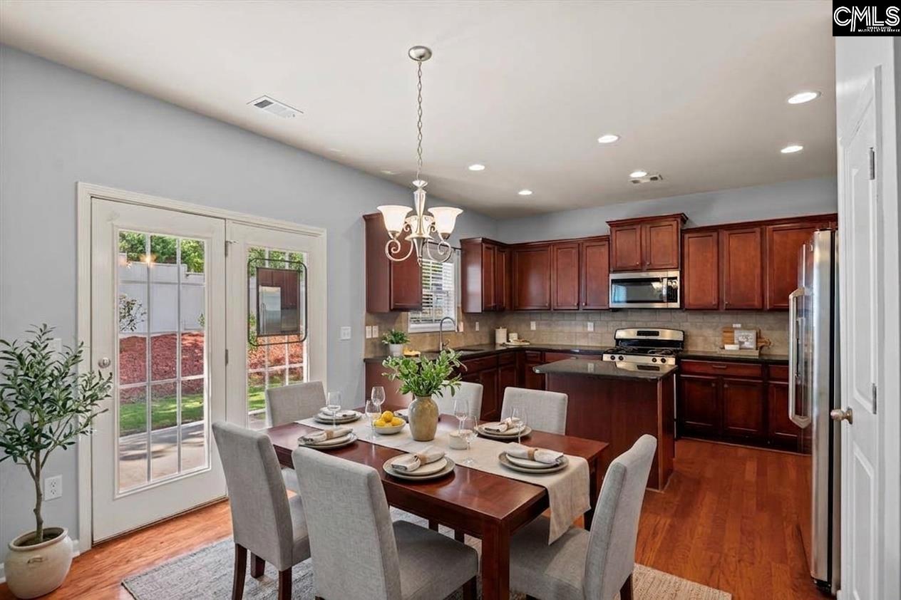 Kitchen and dining area with dark wood cabinets, stainless steel appliances, and French doors to the yard.