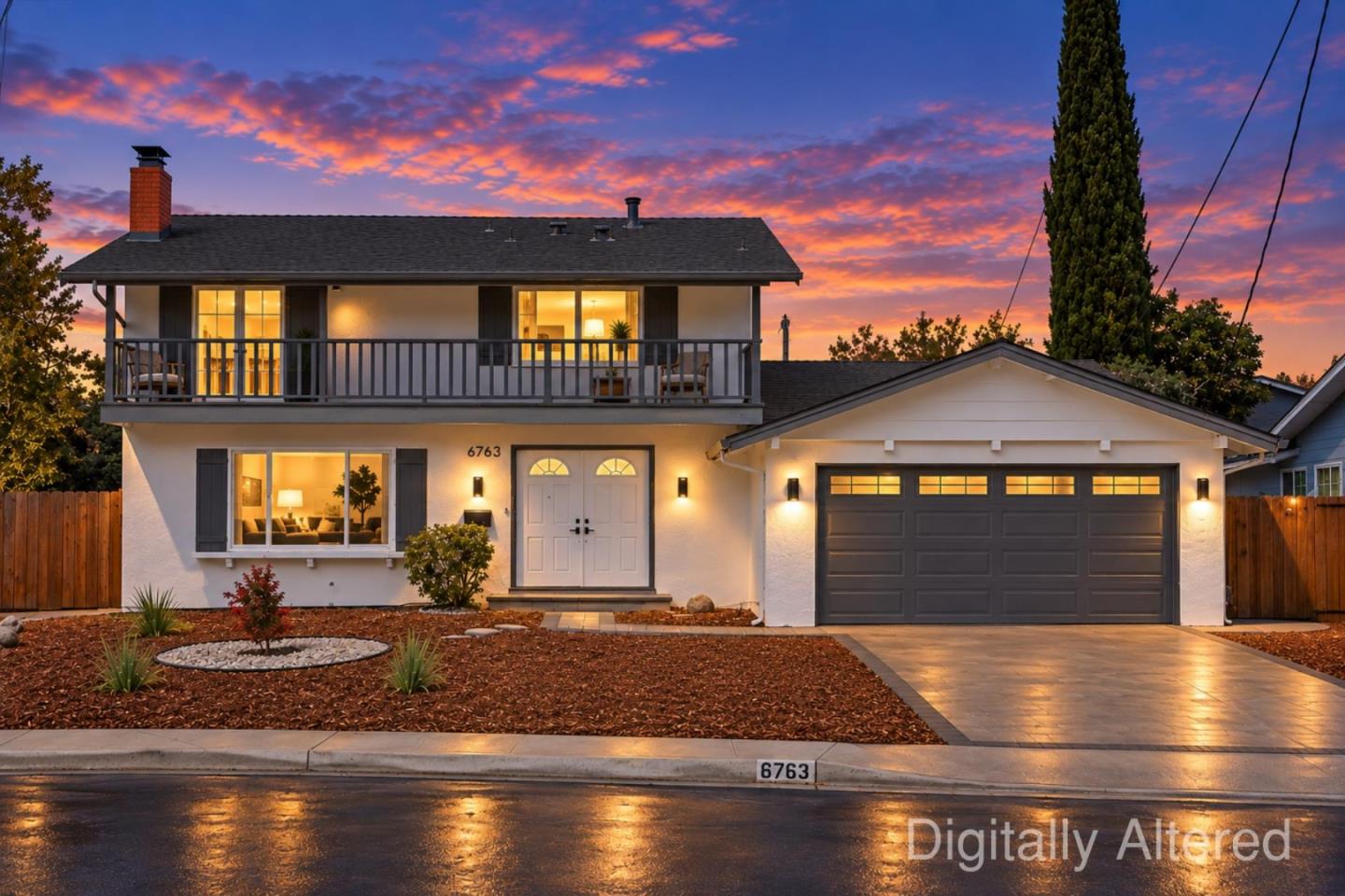 Two-story white house with a balcony and attached garage, glowing warmly beneath a colorful dusk sky.