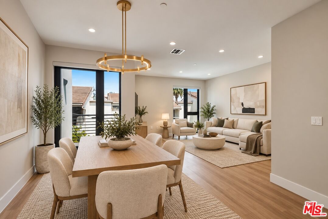 Open-plan dining and living room with a long wood table and cream seating.