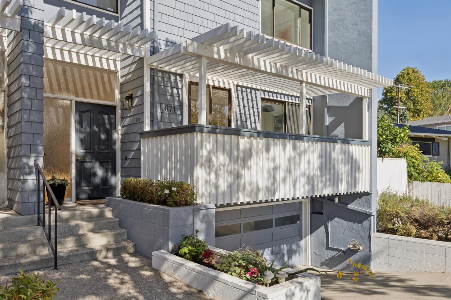 Front exterior of 671 Fox Court with a white pergola, raised porch, and attached garage.