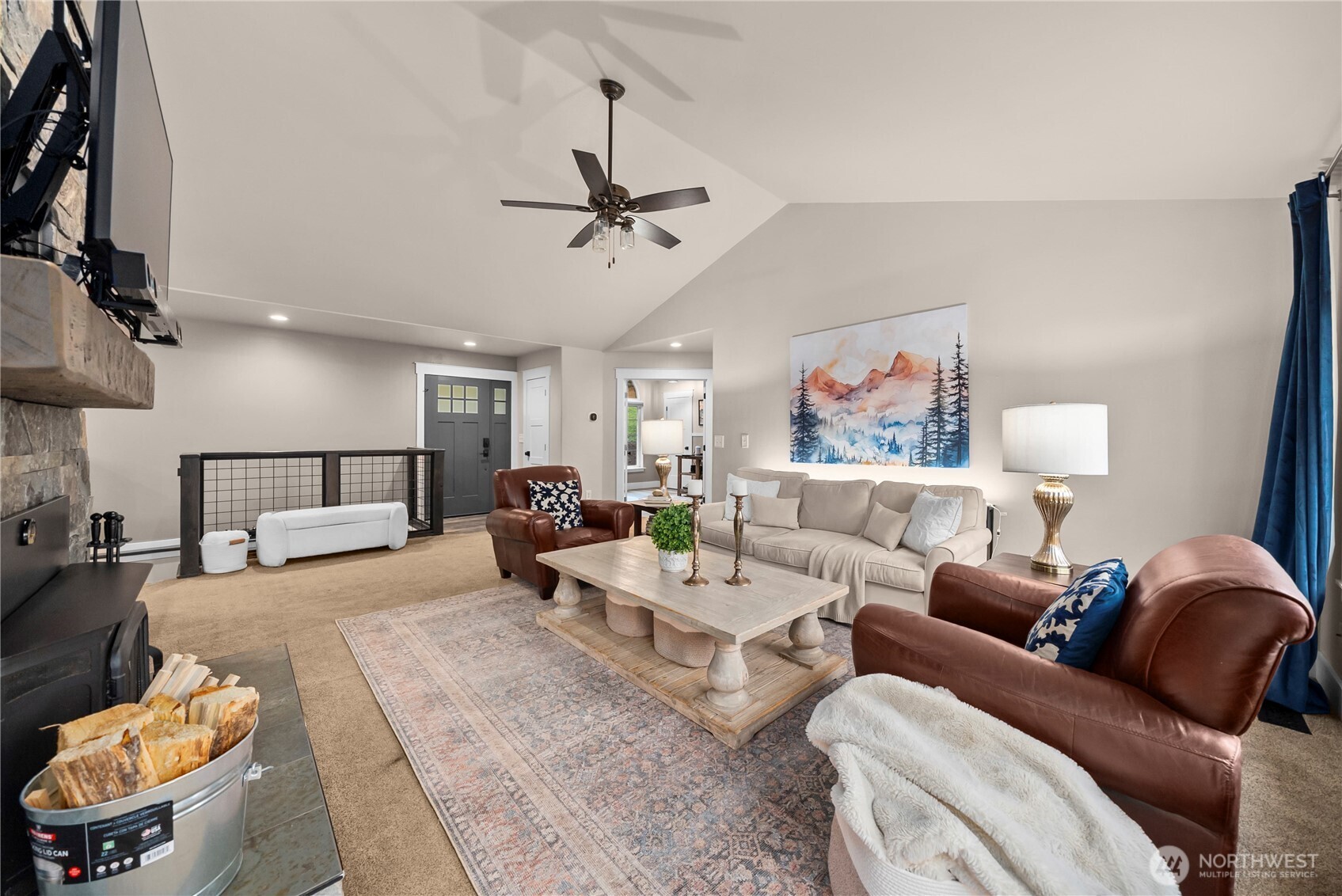 Living room with vaulted ceiling, stone fireplace, and neutral sofa with leather armchairs.