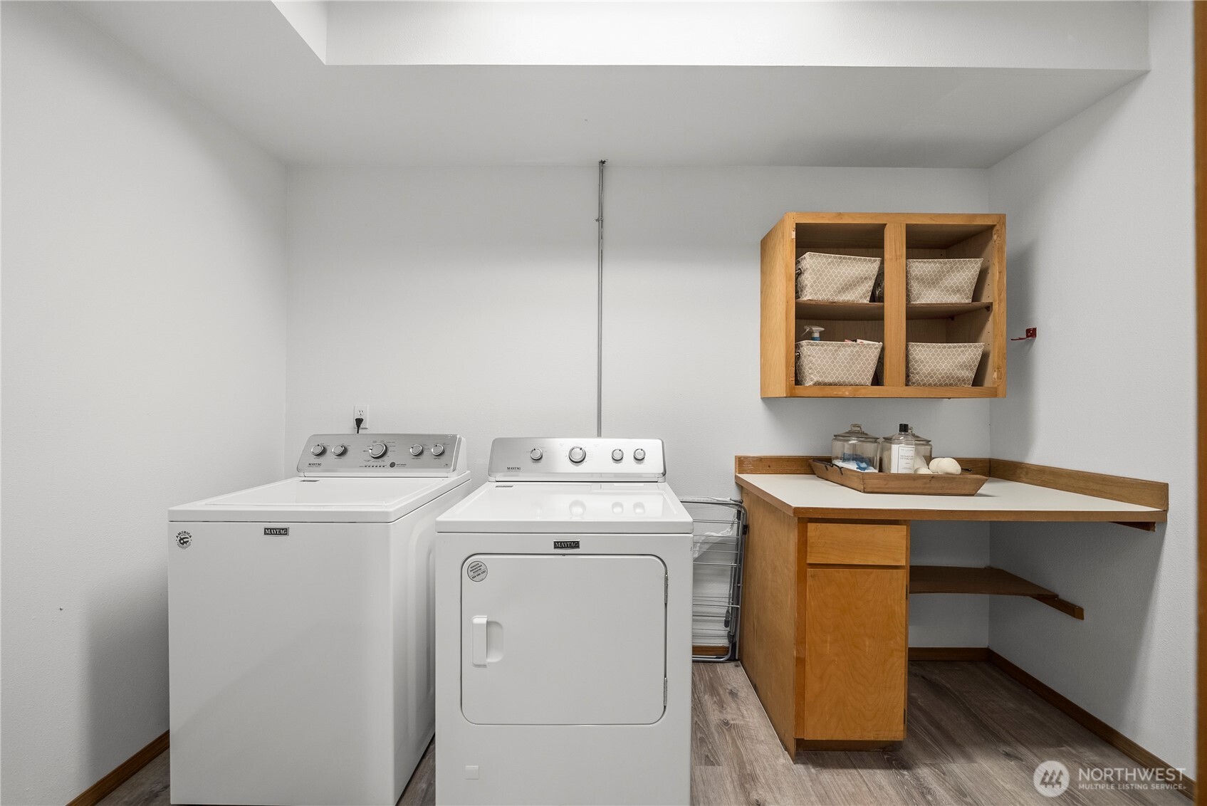 Laundry room with a washer and dryer, wood cabinets, and a built-in folding counter.