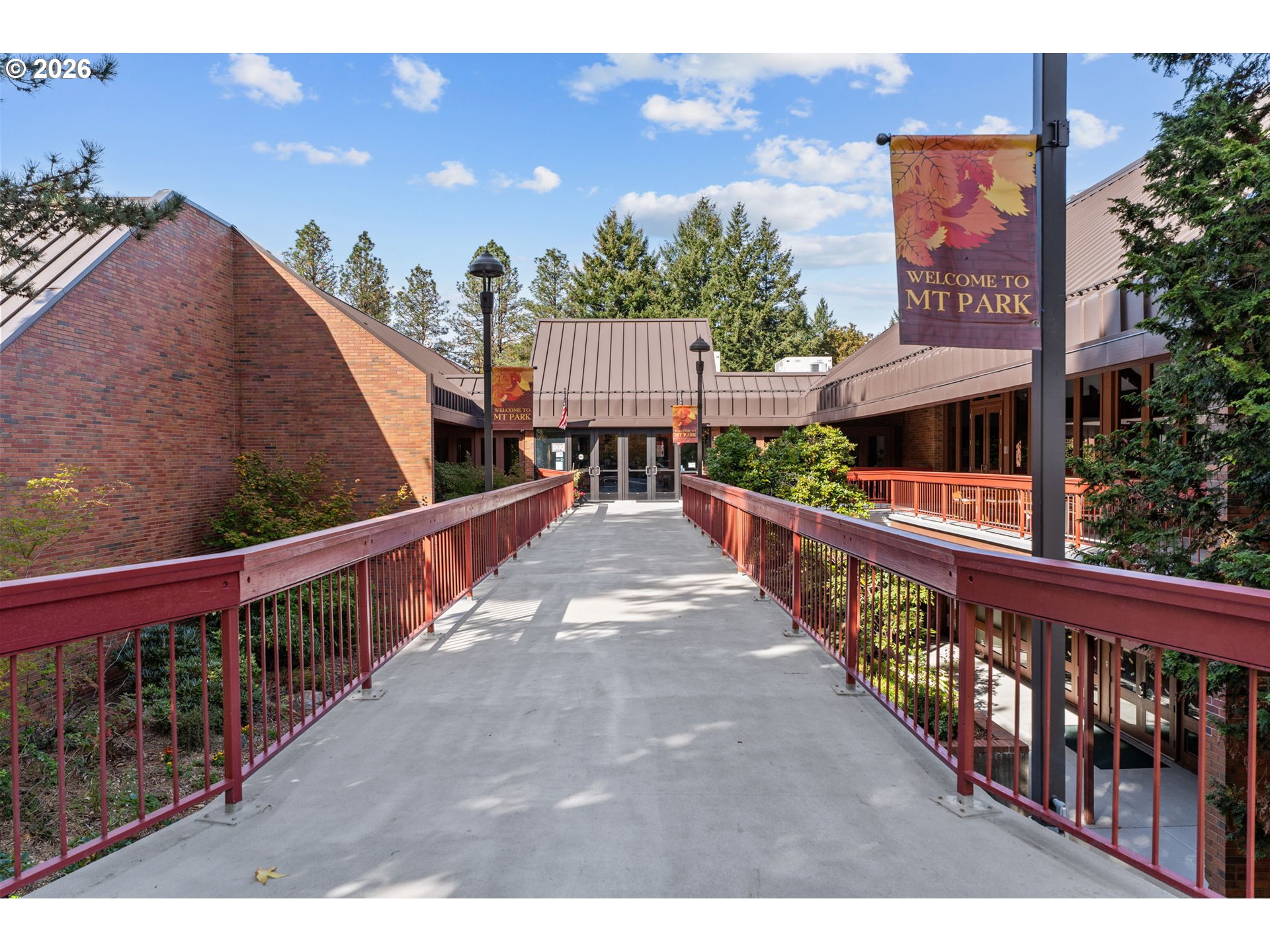Mt Park community building entrance at the end of a concrete walkway with red railings.
