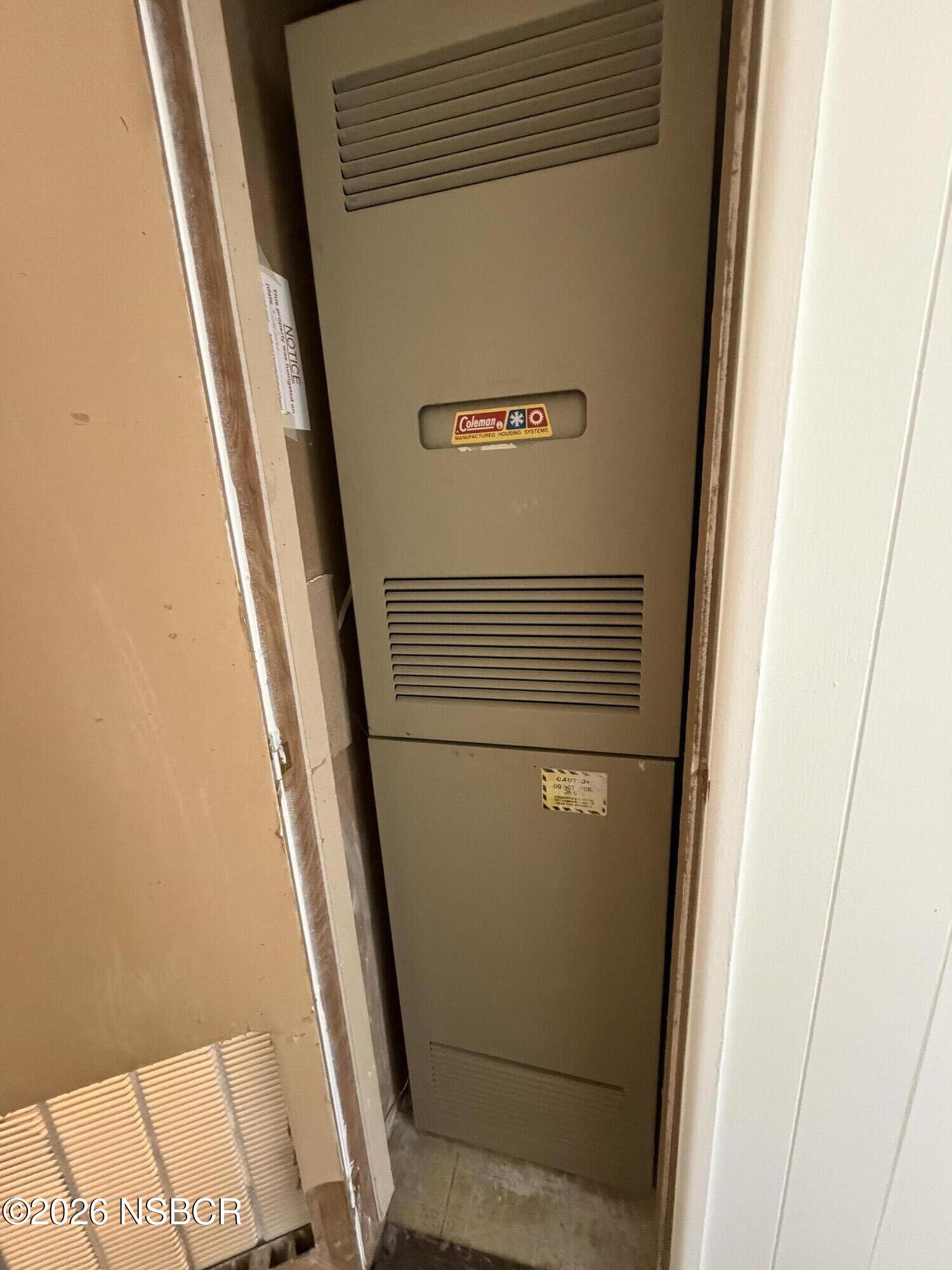 Coleman furnace with vented panels in an interior utility closet.