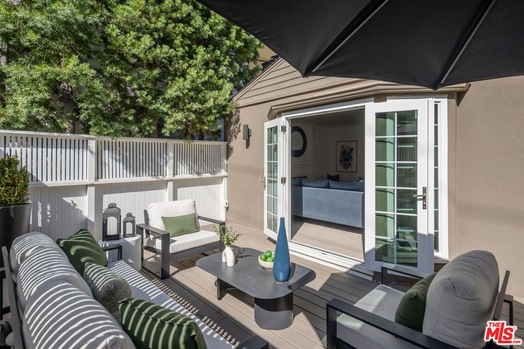 Furnished patio with lounge seating and open French doors leading into the home.