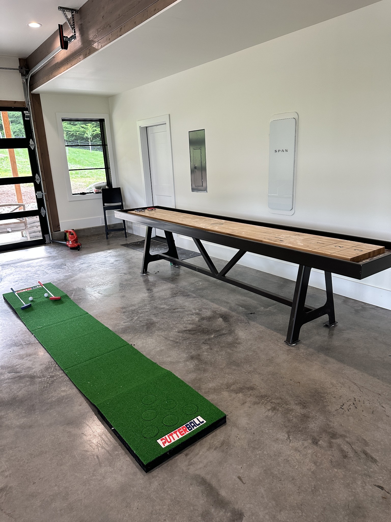 Garage recreation area with a shuffleboard table and PutterBall putting green.