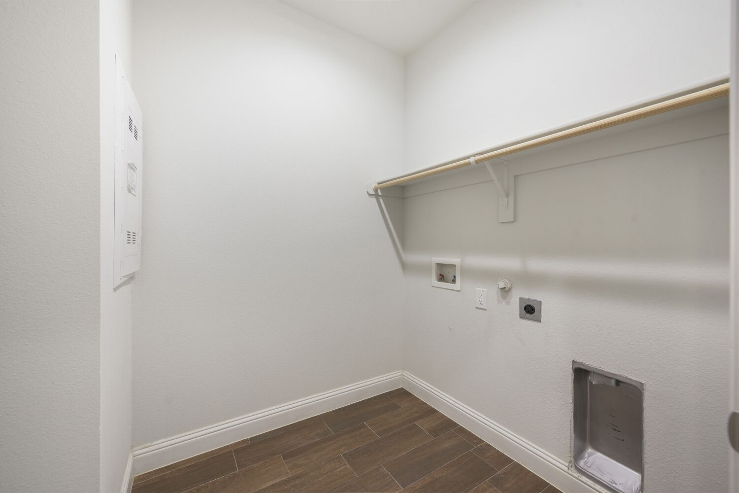 Laundry area with washer hookups, a wall shelf, and a dryer vent.