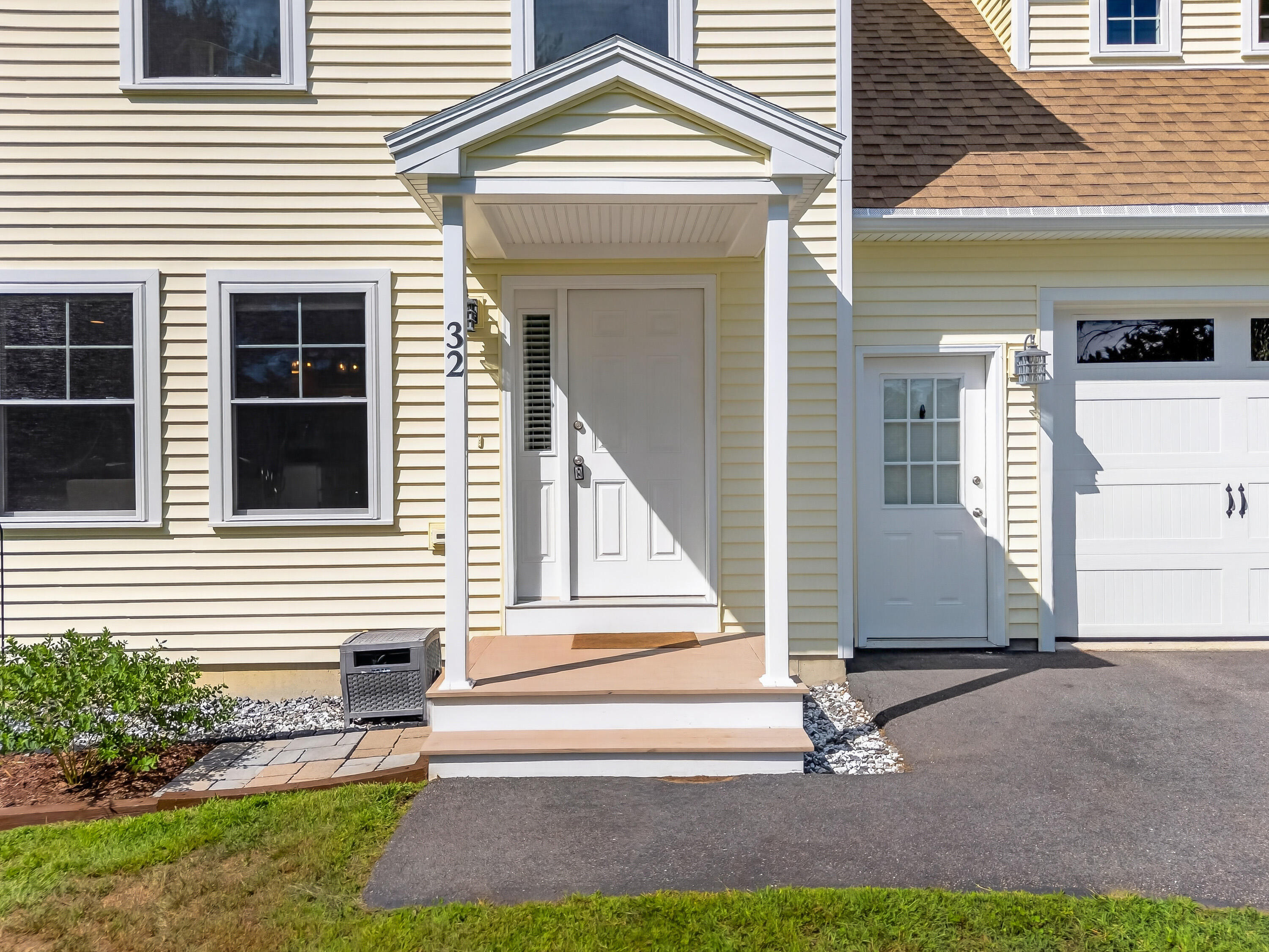 House entrance with a covered porch, white door, and number 32 beside the entry.