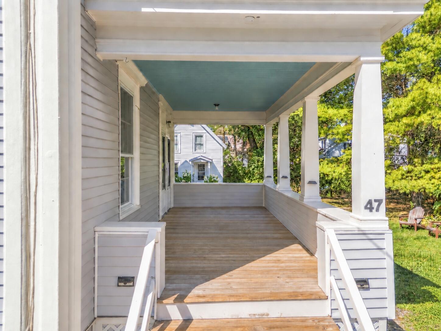 Covered front porch with white columns, teal ceiling, and the number 47 on a post.